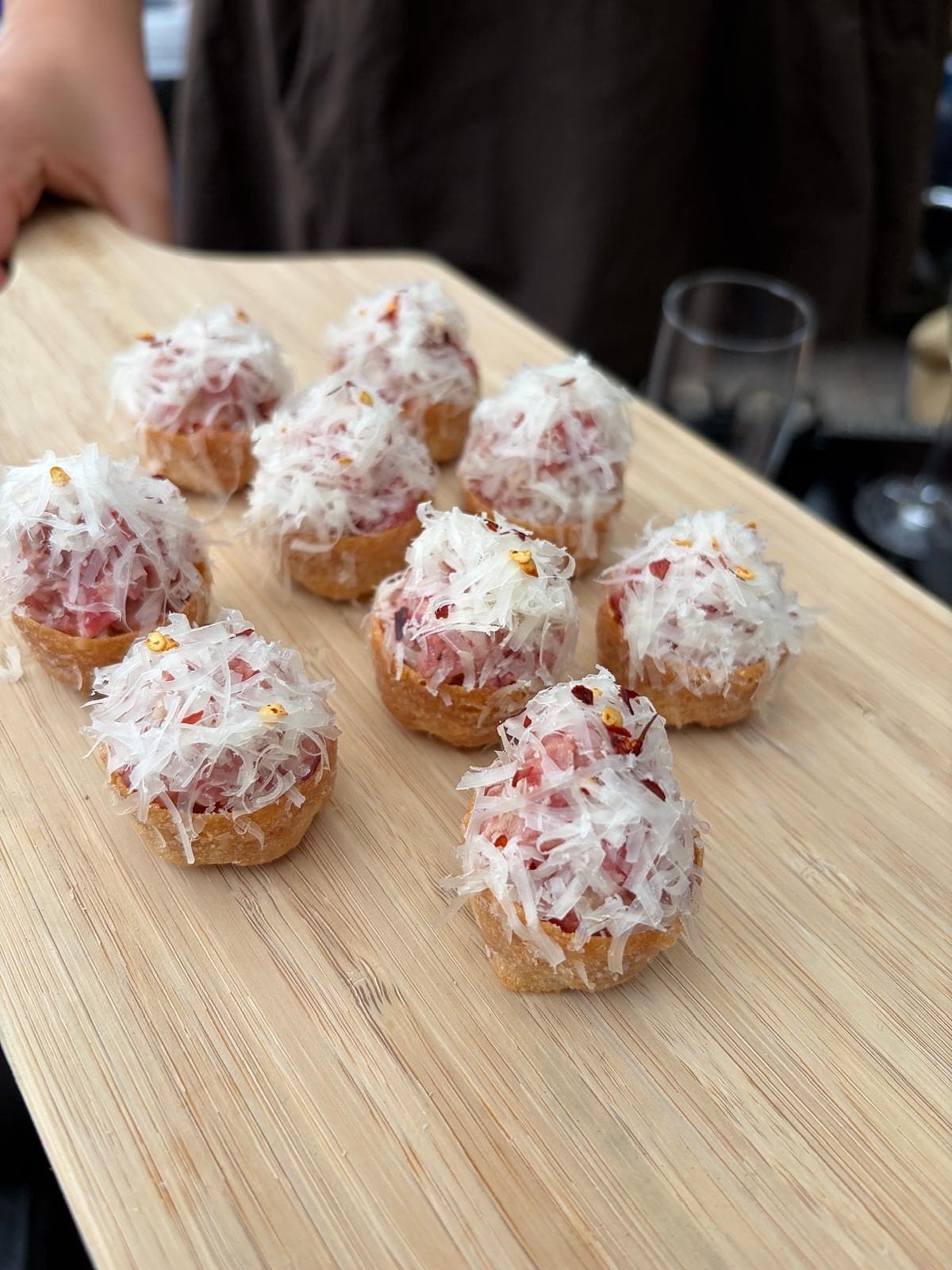 Krokante croustades met rundstartaar en Parmezaan op serveerplank