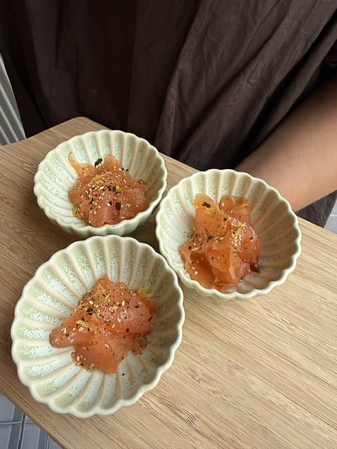 Kleine keramieken kommetjes met zalm en kruiding